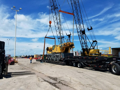 Export Logistics & Shipping, Inc. lifts Liebherr LTM1100 crane with two cranes